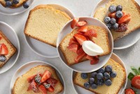 Slices of pound cake on plates topped with fresh fruit and berries