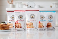 Five different pancake mixes lined up on the counter