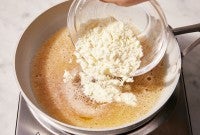 Baker pouring milk powder into browning butter