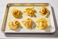 Nests of fresh pasta on a sheet pan