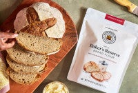 Bag of Baker's Reserve Bread Flour next to a loaf of artisan bread