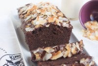 Gluten-Free Coconut Flour Chocolate Cake topped with a Chocolate Glaze and Toasted Coconut Chips