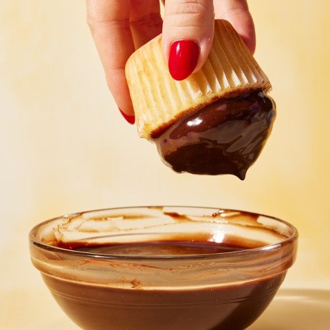 Cupcake being dipped in glaze
