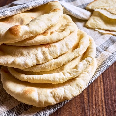 A stack of pita bread on a tablecloth. - select to zoom