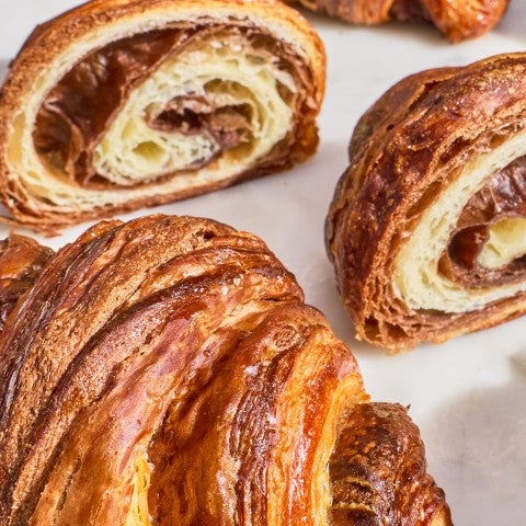 Chocolate bicolored croissant sliced to show the layered interior. - select to zoom