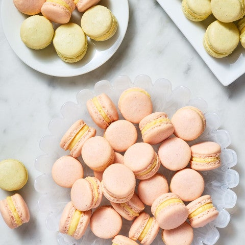 Macaron With Natural Colors arranged on plates atop a marble counter - select to zoom