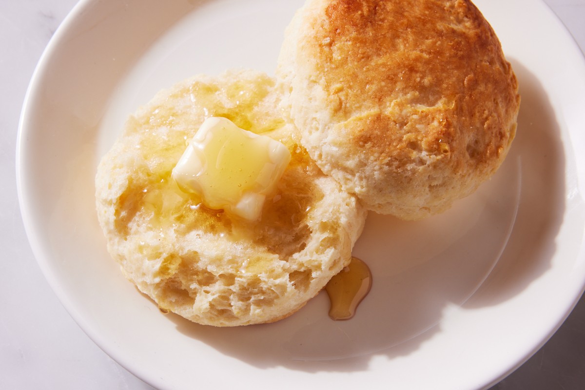 Sliced open buttermilk biscuit with honey and butter