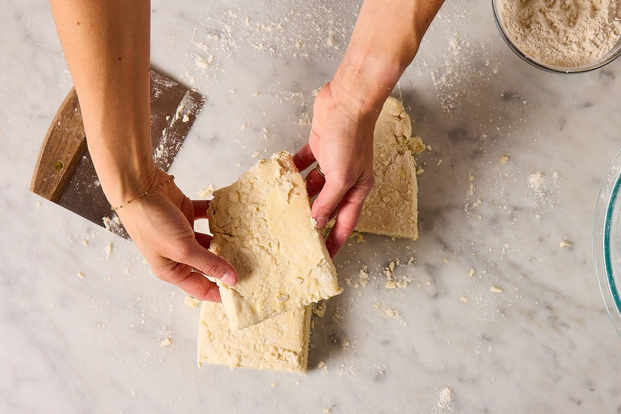Layering cut pieces of biscuit dough.