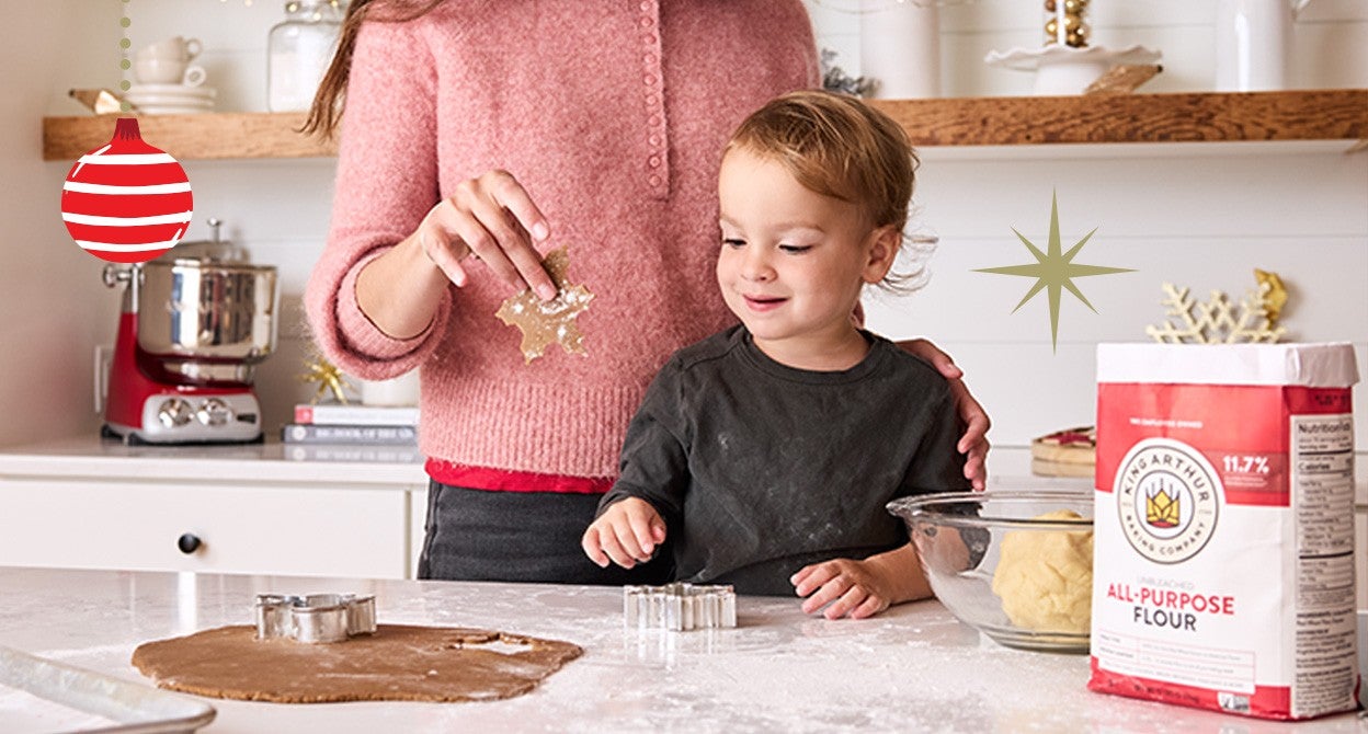 A mother and child making gingerbread cookies in a kitchen