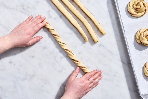 Sun Bun dough being rolled into spiral strips.