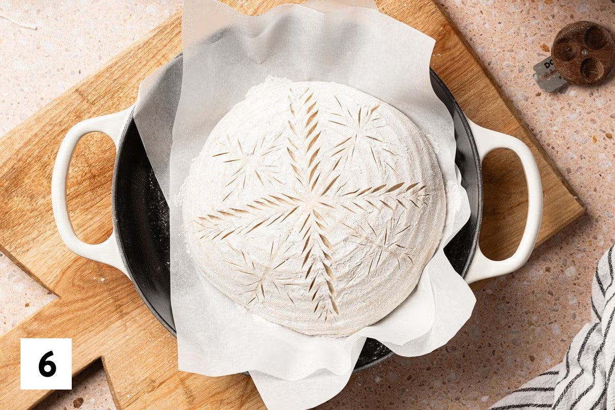 Sourdough bread loaf with a wheat stalk design scored into it 
