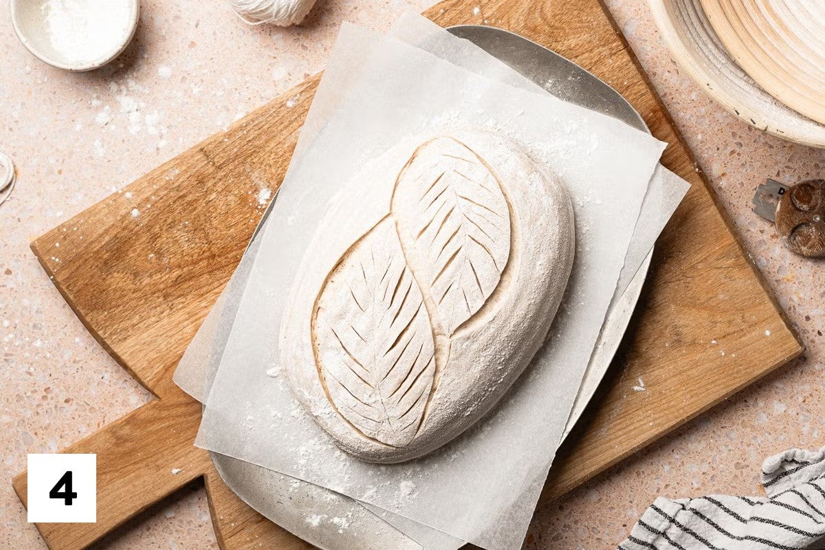 Sourdough bread loaf with a leaf design scored into it 