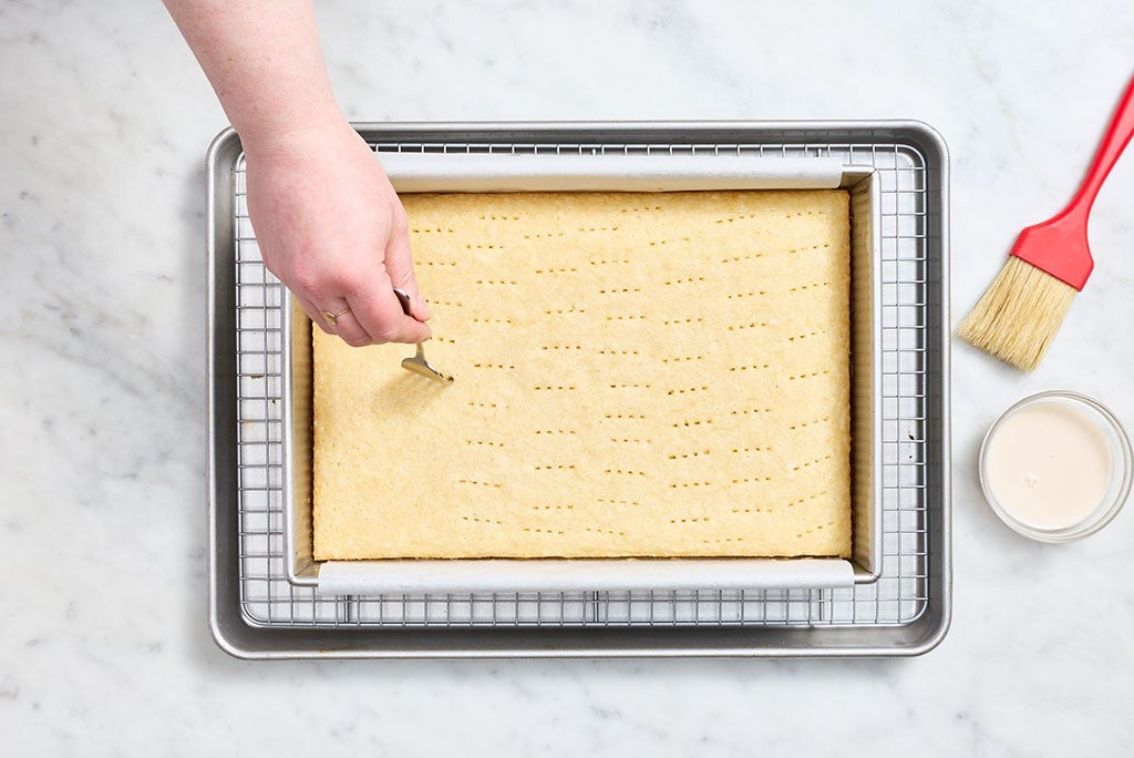 Docking the coconut sheet cake before adding coconut cream.