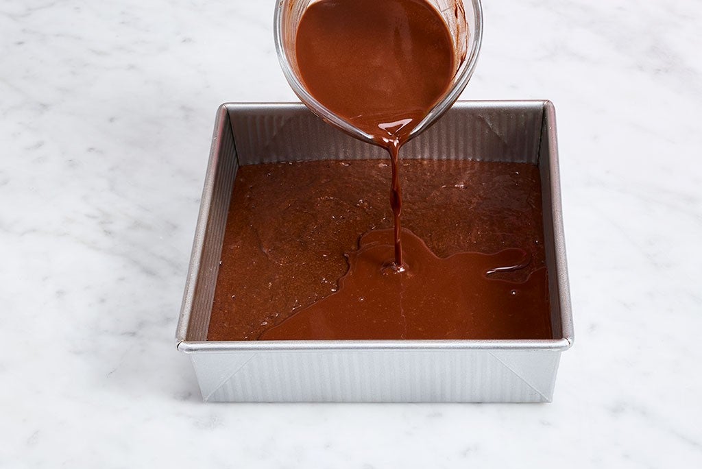 Pouring Sourdough Discard Chocolate Pudding Cake batter into a baking pan.