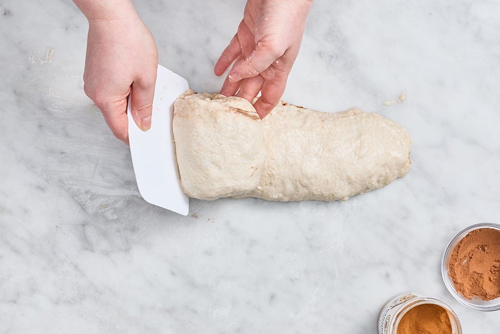 Rolling Apple Cinnamon Sourdough Bread dough on a marble counter