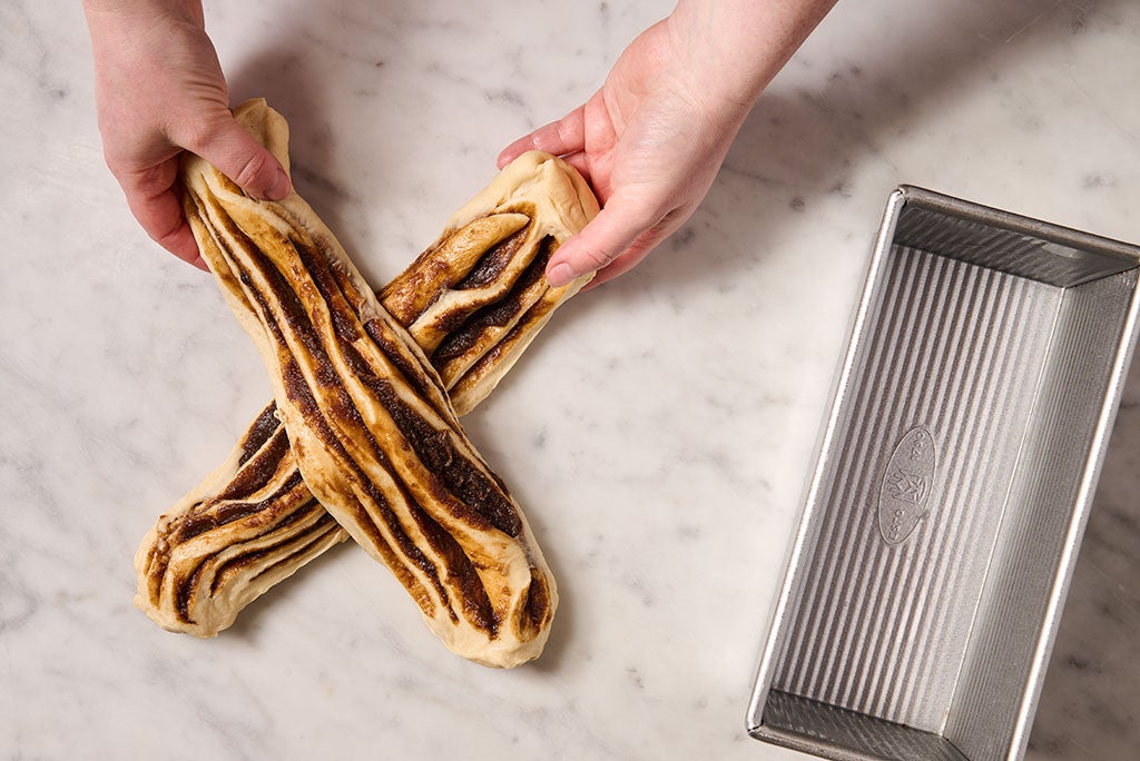 Overlapping two pieces of sliced cinnamon babka bread dough