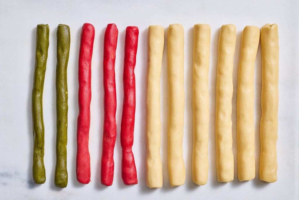 Rolls of colorful Ribboned Peppermint Shortbread Cookies dough arranged on a counter