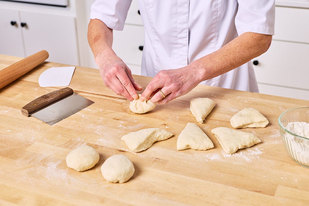 Shaping golden pita bread on a counter