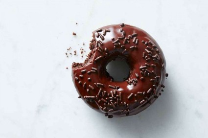 Frosted chocolate doughnut, bite taken out
