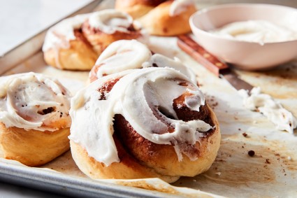 Cinnamon roll with frosting on a tray. 