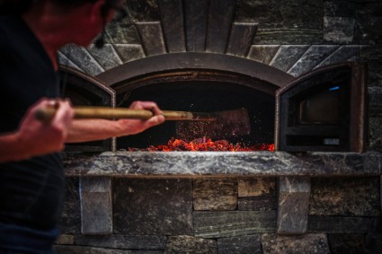 Raking coals in a wood-fired oven