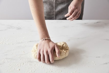 Baker hand kneading dough