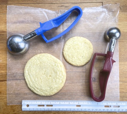 Two Sweet Corn Cookies, one large o ne scooped with a muffin scoop, one smaller scooped with a tablespoon scoop.