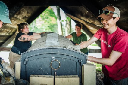 Employee-owner Jesse helps build outdoor oven while volunteering for King Arthur