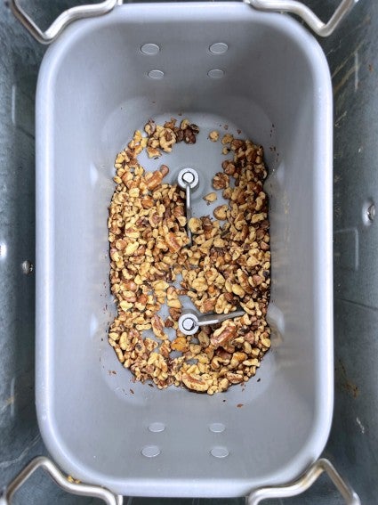 Toasted nuts in a bread machine bucket.