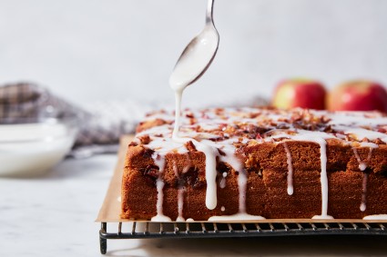 Apple Fritter Cake being drizzled with glaze