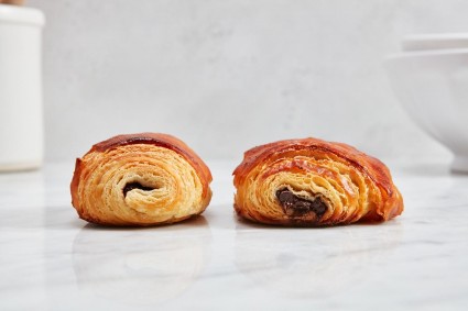 Two pain au chocolat side by side, one having more folds than the other