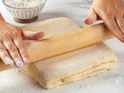 A baker rolling out puff pastry