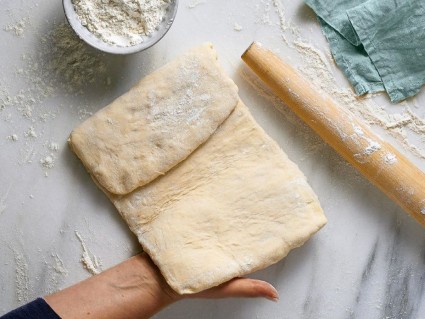 A baker folding laminated dough into thirds