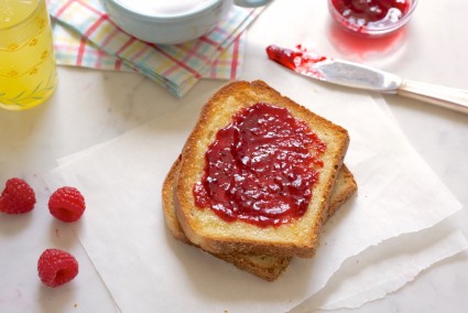 Slice of English Muffin Toasting Bread, toasted and buttered with raspberry jam.