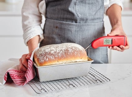 Temperature of yeast loaf interior being taken with a red Thermapen thermometer.