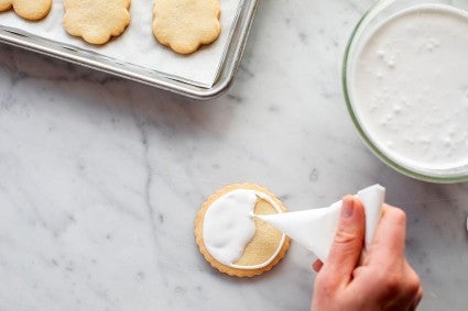 Cornet being used to flood a cookie with icing