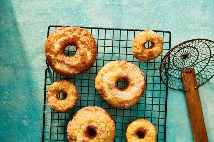 Fried doughnuts on cooling rack next to a spider