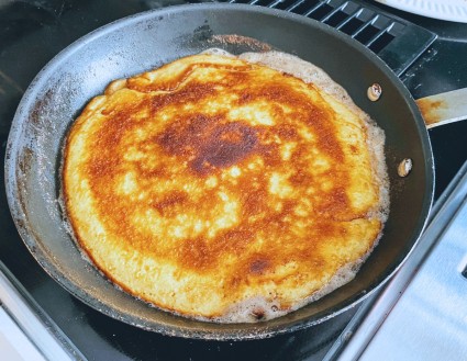 Kaiserschmarrn in a frying pan, deep-golden cooked side up.
