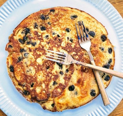 Kaiserschmarrn on a plate with two forks, ready to tear into pieces and serve.