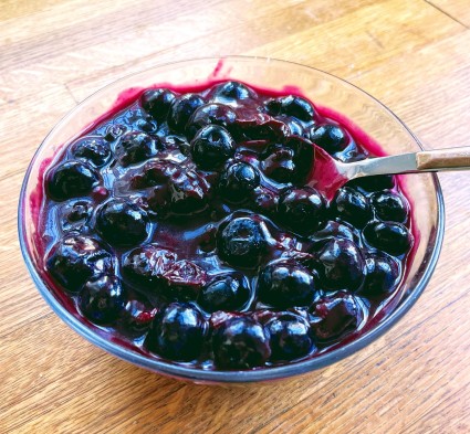 Blueberry compote in a clear glass bowl.