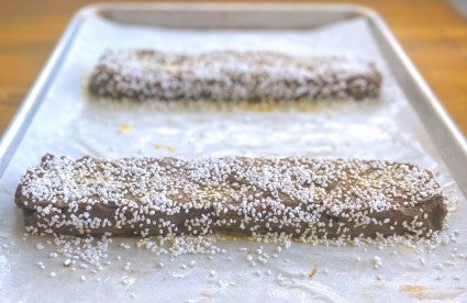 Malted Brownie Biscotti dough shaped into logs, topped with sugar, and ready to bake.