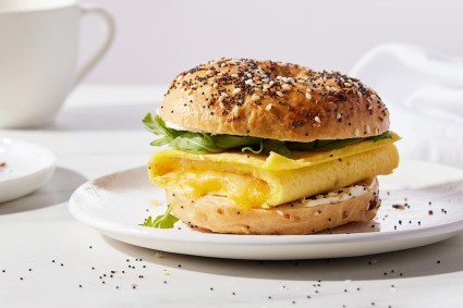 An Ultimate Sandwich Bagel filled with eggs, cheese, and greens