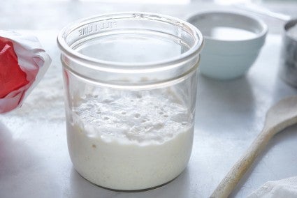 Sourdough starter in a glass mason jar, waiting to be fed.