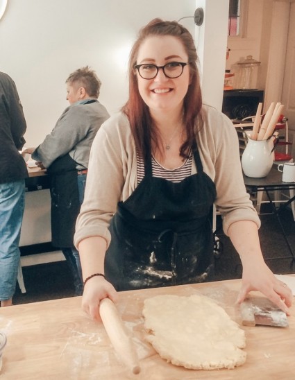Author at a work surface rolling out pie crust