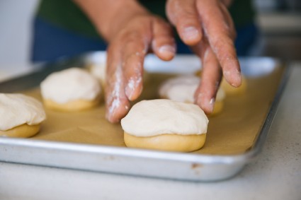 Placing unbaked masa harina cookie topping on roll 