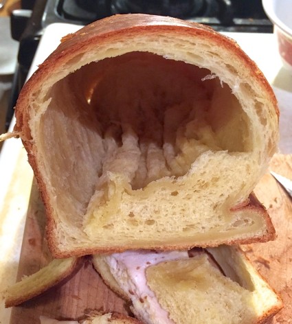 Loasf of bread cut crosswise to show a perfectly hollow interior with mush in the bottom.