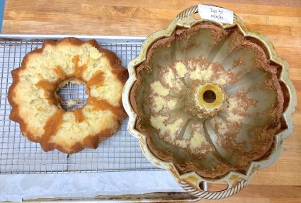 Bundt cake and bundt pan side by side on a cooling rack, the top of the cake having gotten stuck in the pan