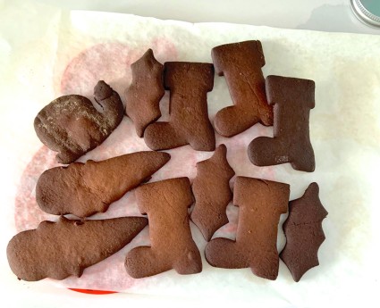 Severely burned gingerbread Christmas cookies on a piece of parchment.