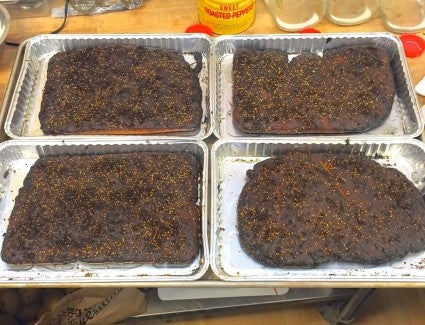 Four za'atar focaccia on half-sheet pans, burned to a black crisp.