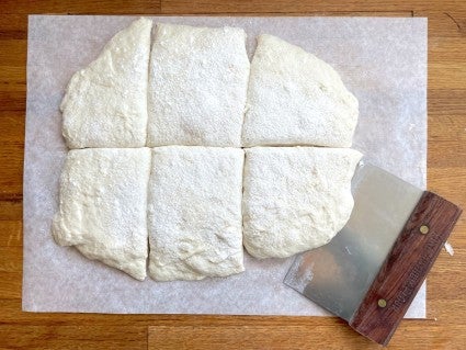 Sourdough Pan de Cristal on a sheet of greased parchment cut into six flat loaves